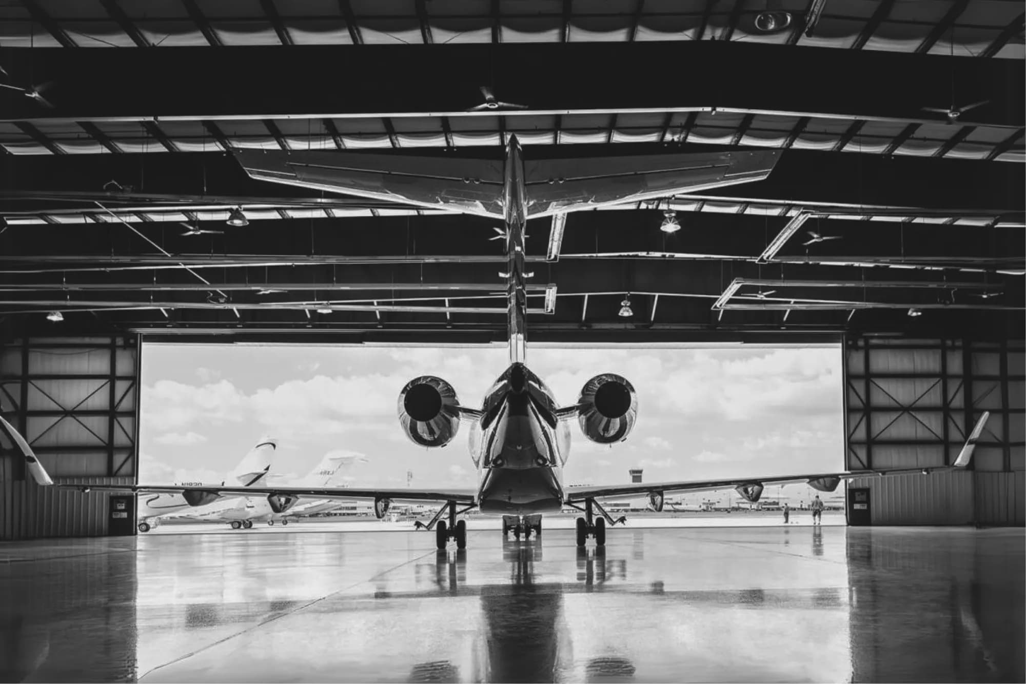The back of a jet towards an opening hangar from the inside